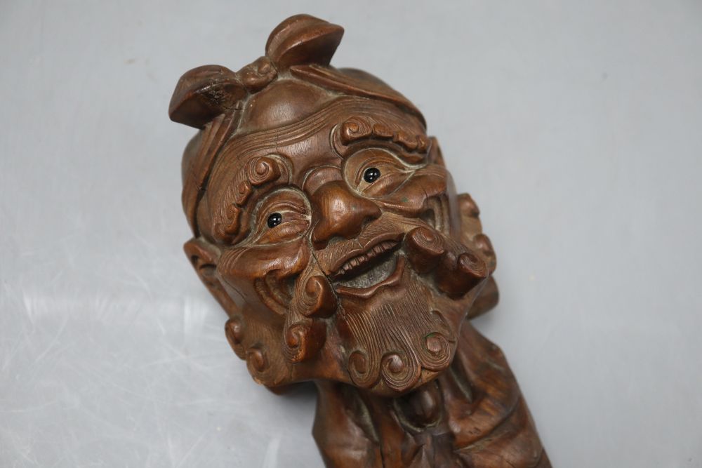 An Oriental carved hardwood head of immortal, with glass eyes, height 22cm